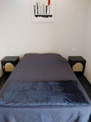- une chambre avec un lit avec deux tables et une photo sur le mur dans l'établissement Le Rubis, à Gruissan