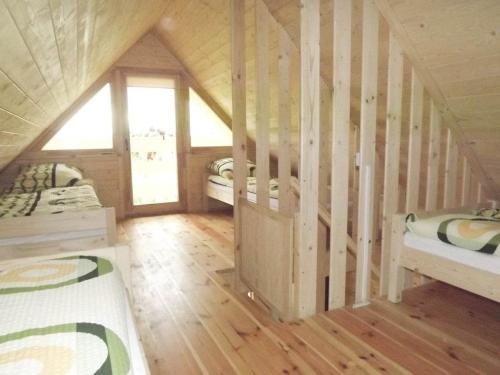 a room with two beds in a wooden cabin at Domki Biały Żagiel Centrum Ustronia Morskiego in Ustronie Morskie