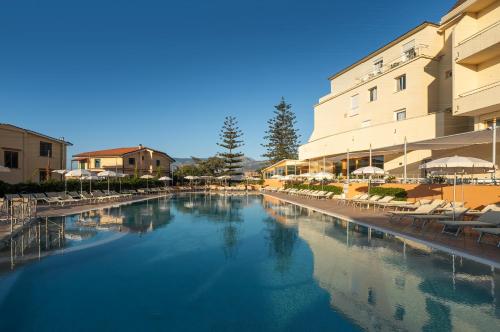 uma piscina num hotel com cadeiras e guarda-sóis em Grand Hotel Vesuvio em Sorrento