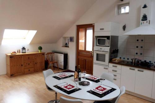 une cuisine avec une table et des chaises dans une pièce dans l'établissement le Loft de Gérardmer - Cozy et spacieux, à Gérardmer