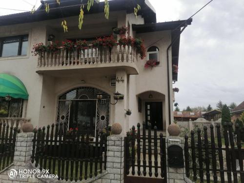 a house with a fence and flowers on the balcony at Soba Sekulić in Sombor