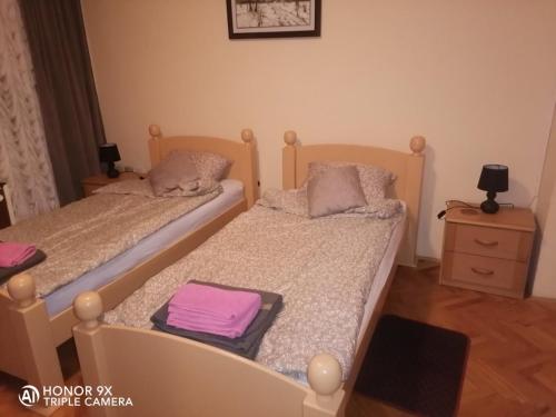 two twin beds in a bedroom with a dresser at Soba Sekulić in Sombor