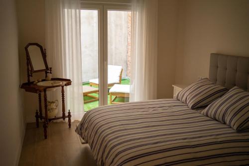 Schlafzimmer mit einem Bett und einem Fenster mit einem Stuhl in der Unterkunft Apartamento NUEVO en el centro de LEON in León