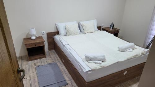 una camera da letto con un grande letto con lenzuola e cuscini bianchi di ETNO Selo STRAŽA a Pirot
