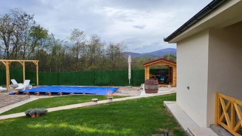 皮羅特的住宿－ETNO Selo STRAŽA，后院设有蓝色蹦床和绿色围栏