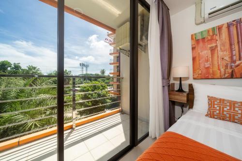 a bedroom with a bed and a large window at Tropical Living Mai Khao Beach in Ban Bo Sai Klang