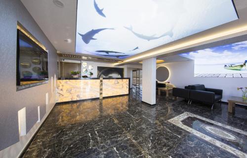 a lobby with a large mural of dolphins on the ceiling at Sarp Hotel Kadriye in Belek