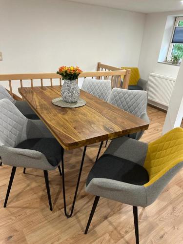 a wooden table with chairs and a vase with flowers at Studio Reichenstrasse in Quedlinburg