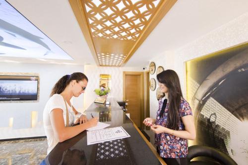 two women standing in a room looking at something at Sarp Hotel Kadriye in Belek