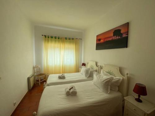 - une chambre d'hôtel avec 2 lits avec des chaussures dans l'établissement Casa da Rocha, à Armação de Pêra