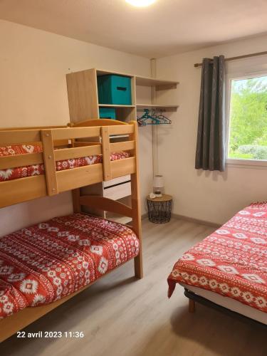 une chambre avec deux lits superposés et une fenêtre dans l'établissement Villa tout confort dans résidence privée avec piscine à 500m de la plage - Climatisation, WIFI, parking, à Portiragnes