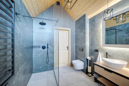 La salle de bains est pourvue d'une douche et d'un lavabo. dans l'établissement Rezydencja Widok, à Kluszkowce