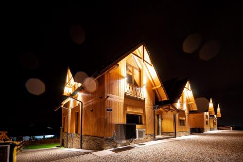 a building with lights on the side of it at night at Rezydencja Widok in Kluszkowce