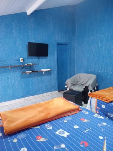 een kamer met een bed en een blauwe muur bij El Viajero Hostel & Suítes 10 in Pedro Juan Caballero
