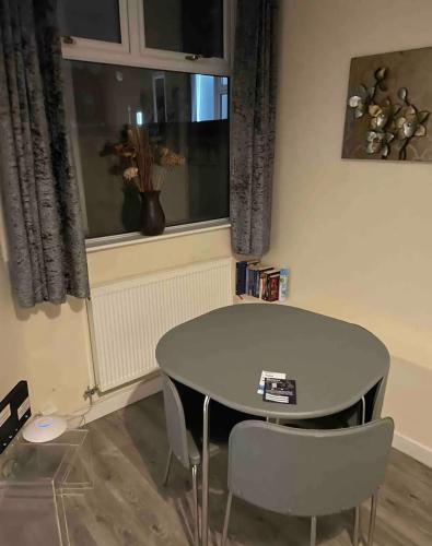a table and chairs in a room with a window at Ensuite Room, Hotel Standard. Close to Crewe Train Station in Crewe