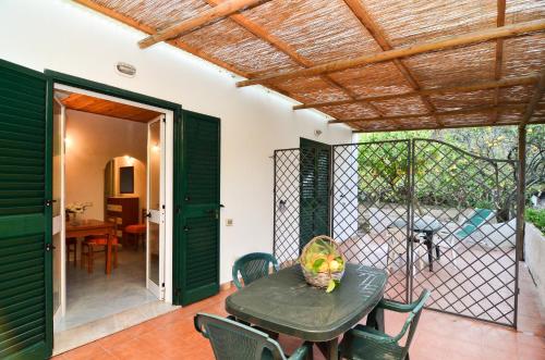 a patio with a table and chairs and a fence at Residence Limoneto Ischia in Ischia