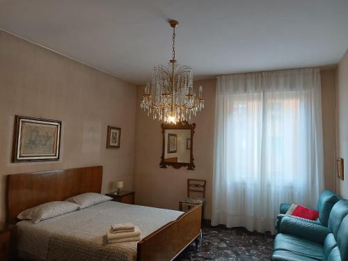 sypialnia z łóżkiem i żyrandolem w obiekcie Affittacamere Pratello 97 w Bolonii