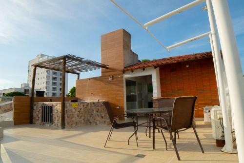 eine Terrasse mit einem Tisch und Stühlen auf dem Dach in der Unterkunft Casa Hotel Jardín Plaza in Santa Marta