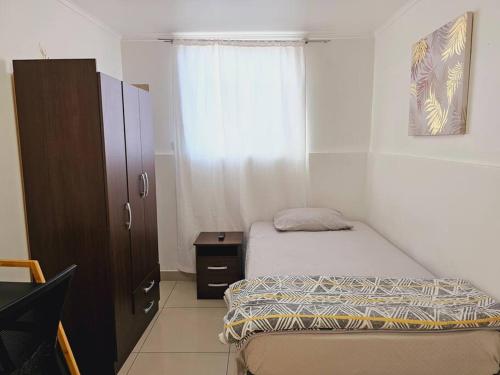 Habitación pequeña con cama y ventana en Alojamiento Privado 403 en Antofa, en Antofagasta