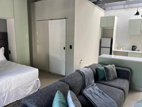 uma sala de estar com um sofá e uma cama em 31 on Forest (Matamela Suite) em Joanesburgo