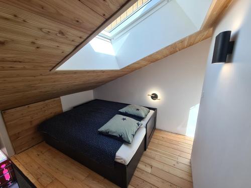 une petite chambre avec un lit dans un grenier dans l'établissement CMD Méribel, à Méribel