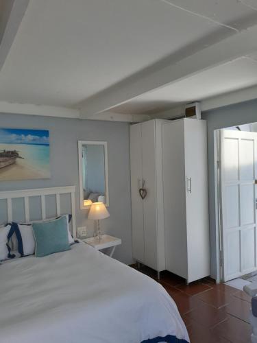 a bedroom with a white bed and a white cabinet at 16 on Point in Parow