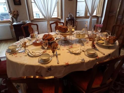 Una mesa con un mantel blanco con comida encima. en MAISON GAY LUSSAC St LEONARD DE NOBLAT, en Saint-Léonard-de-Noblat