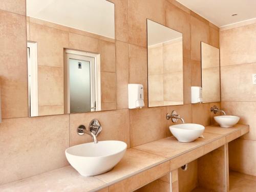 a bathroom with two sinks and two mirrors at Paradise Beach Camping in Paradise Beach