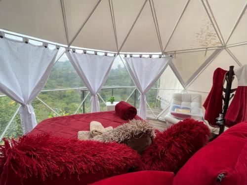 ein Schlafzimmer mit einem roten Bett in einem Zelt in der Unterkunft GLAMPING LA CRISTALINA in Jamundí