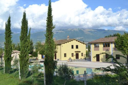 a villa with a pool and mountains in the background at agriturismo villaggio green in Montefalco