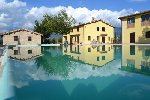 een reflectie van twee gebouwen in een plas water bij agriturismo villaggio green in Montefalco