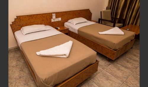 two beds in a hotel room with towels on them at Hotel Sri Ram Residency in Udupi