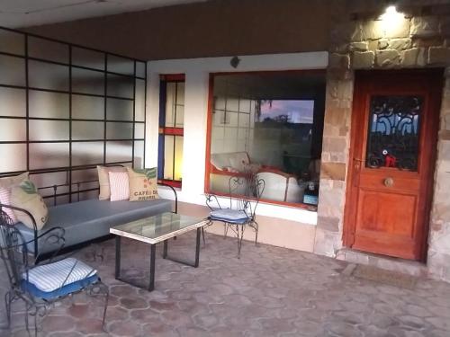 a patio with a couch and chairs and a table at LOS TEROS POSADA DE CAMPO in San Rafael