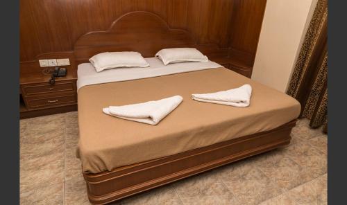 a bed with two white towels on top of it at Hotel Sri Ram Residency in Udupi