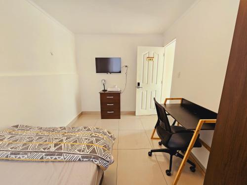 1 dormitorio con cama, escritorio y silla en Alojamiento Privado 403 en Antofa, en Antofagasta