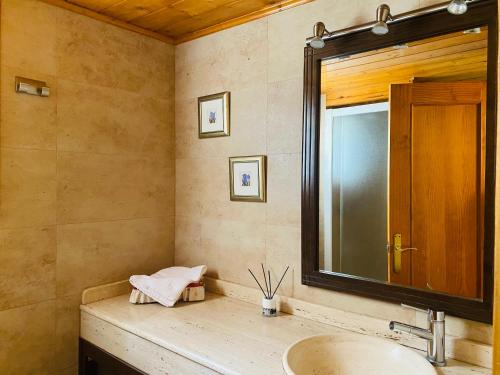 uma casa de banho com um lavatório e um espelho em Casa Martagón - kasasbenas em Benasque