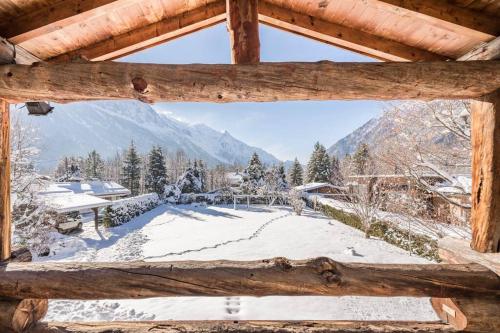 a view from a log cabin window of a snow covered yard at Spectacular Chalet with 5 ensuite bedrooms and sauna in Chamonix-Mont-Blanc