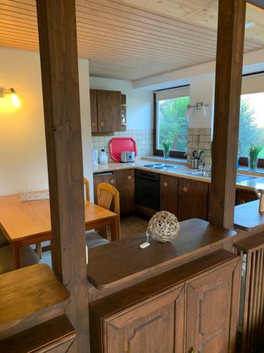 a kitchen with wooden cabinets and a table and a dining room at Ferienwohnung Losenberg in Olsberg