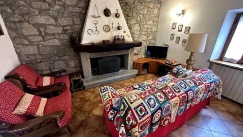 uma sala de estar com uma cama e uma lareira em Vale House em Faidello