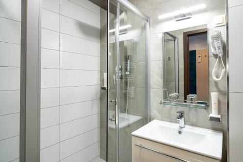 y baño con lavabo y ducha. en Inter Hotel, en Debrecen