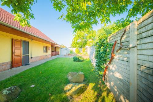 a yard with a fence next to a house at Zöld dió Vendégház in Mezőkövesd