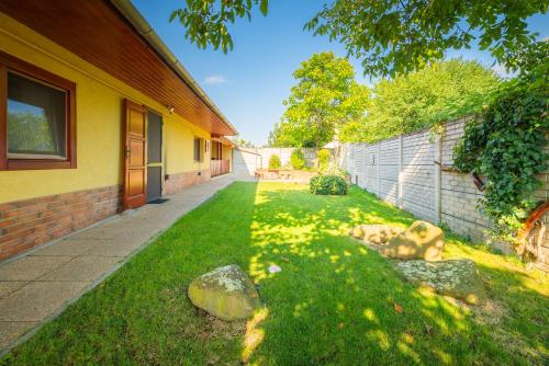 a house with a grass yard next to a building at Zöld dió Vendégház in Mezőkövesd
