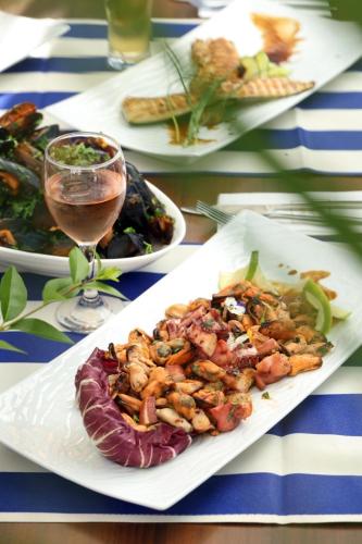 a table with plates of food and a glass of wine at Rome Palace Deluxe - All Inclusive Premium in Sunny Beach