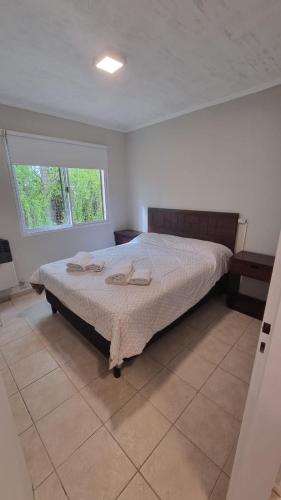1 dormitorio con 1 cama con 2 toallas en Moreno Apart 2 en El Calafate