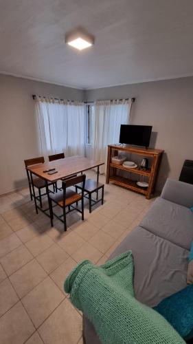 sala de estar con mesa y sofá en Moreno Apart 2 en El Calafate