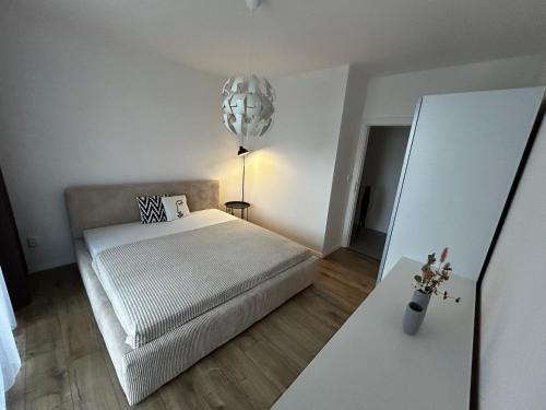 a bedroom with a bed and a pendant light at Apartmán Rezidencia POVRAZY II in Košice