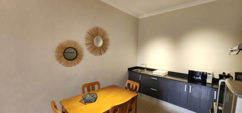 a dining room with a table and a mirror at Appartment 4 (Garden View), Pebble Bay Appartments in Grand Baie
