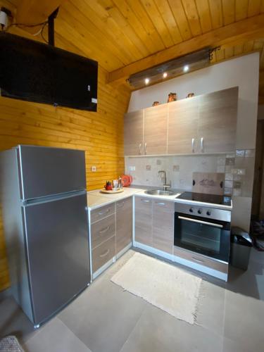 a kitchen with stainless steel appliances and wooden walls at Apartmani Snježna Kraljica Vlašić 1 in Vlasic