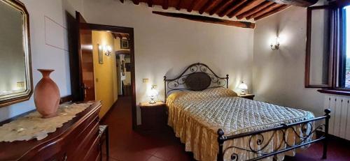 ein Schlafzimmer mit einem Bett und einer Vase auf einem Tisch in der Unterkunft Girasole 1 in Lucca