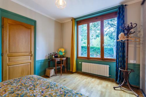 Schlafzimmer mit einem Bett und einem Fenster in der Unterkunft Les Magnolias in Oullins